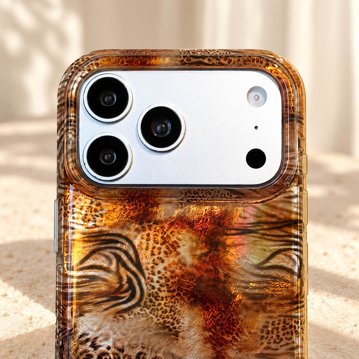 Camera surround and upper-edge detail of the Animal Mix Amber Shimmer iPhone case.