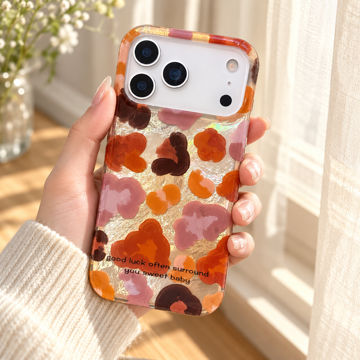 Autumn Mix floral case held beside a softly lit cream curtain, showing the glossy back from a gentle angle.