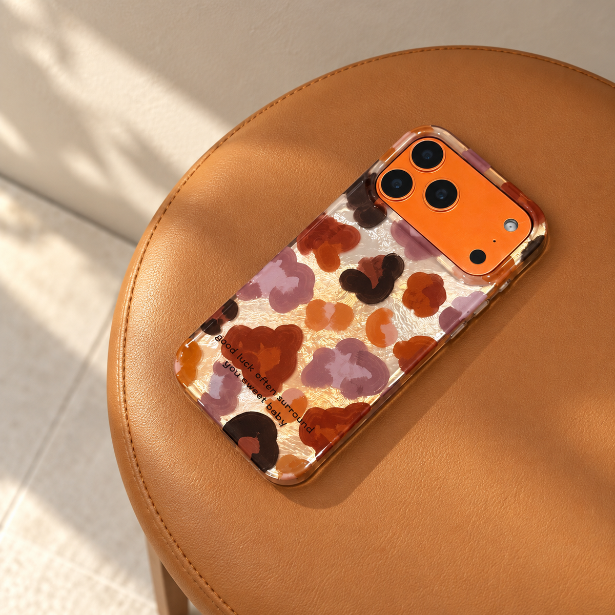 Autumn Mix floral case resting diagonally on a caramel-coloured seat with the complete design visible.