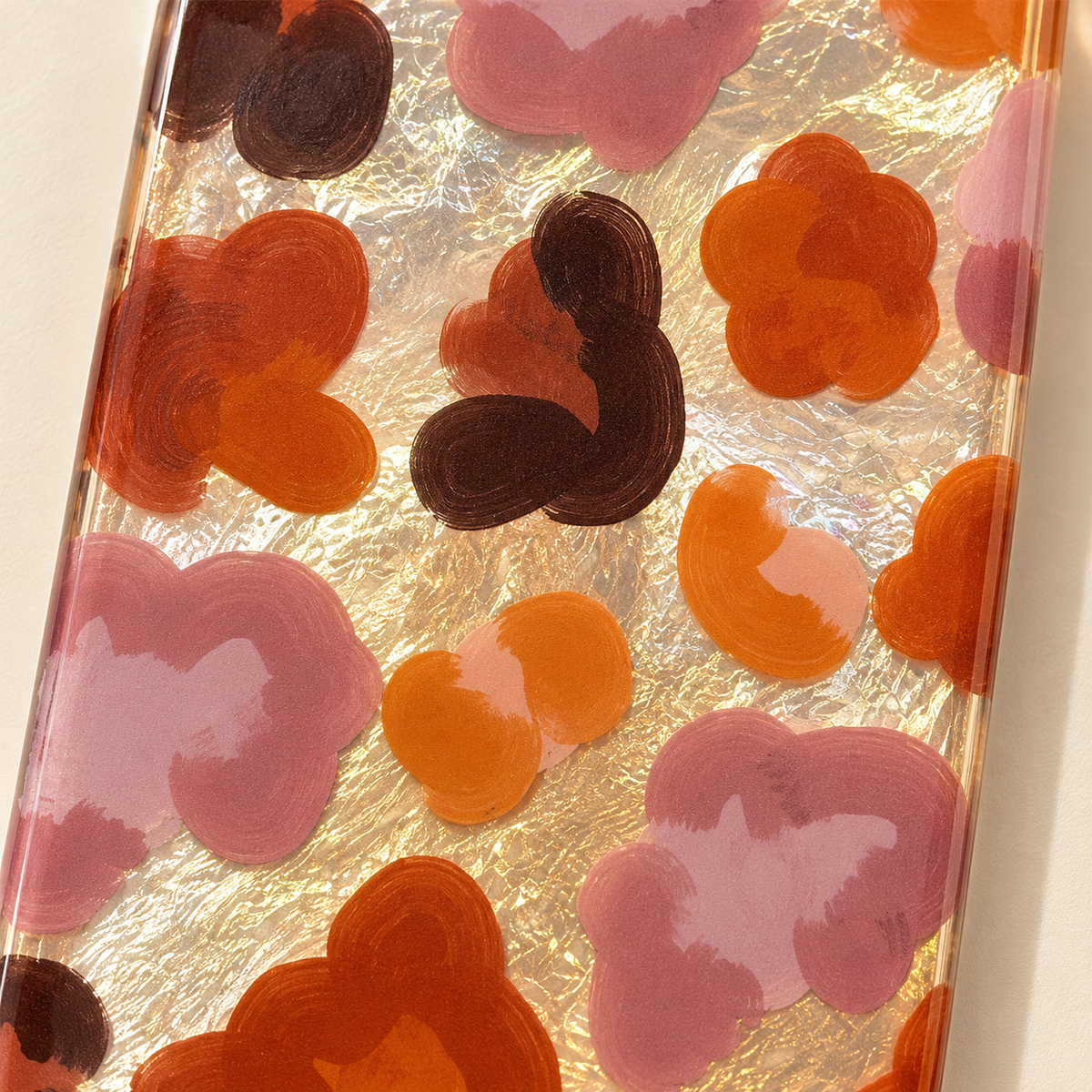 Central floral detail of the Autumn Mix case, showing cocoa, rust and mauve shapes over the reflective background.