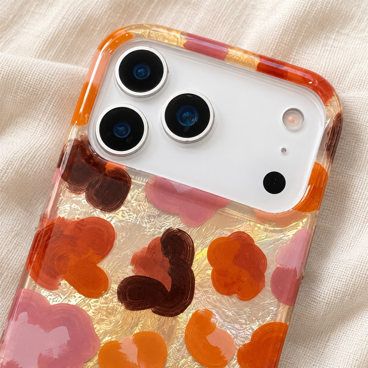 Upper detail of the Autumn Mix case showing its wide camera opening, amber-tinted rim and floral print.