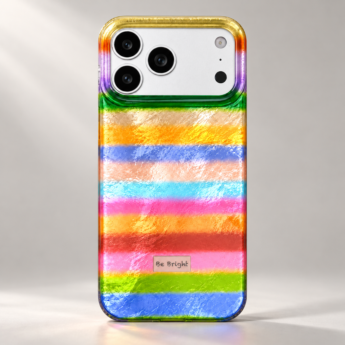 Be Bright rainbow stripe iPhone case — angled reflective finish view.
