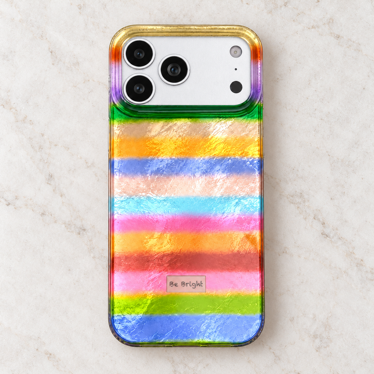 Be Bright rainbow stripe iPhone case — elevated rear studio view.