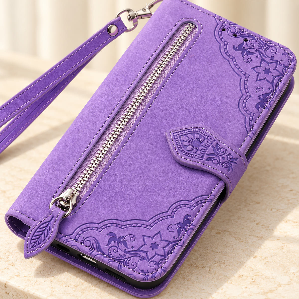 Close-up of the Lavender Botanical wallet case showing the silver zipper, leaf-shaped pull, embossed floral border and stitching.