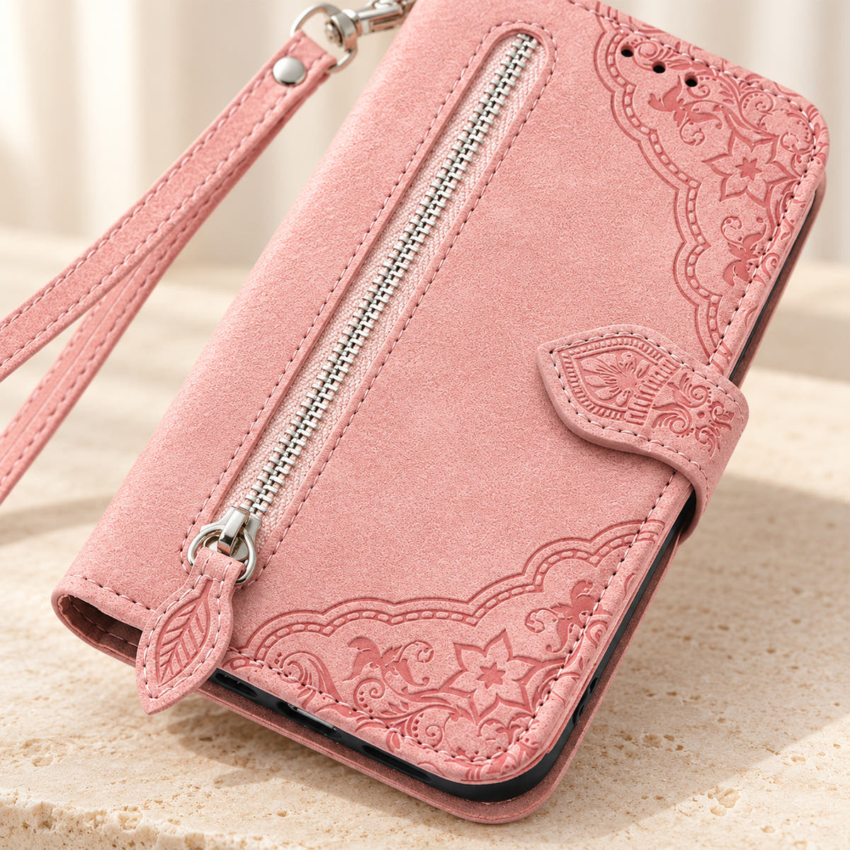 Close-up of the Pink Botanical wallet case showing the silver zipper, leaf-shaped pull, embossed floral border and stitching.