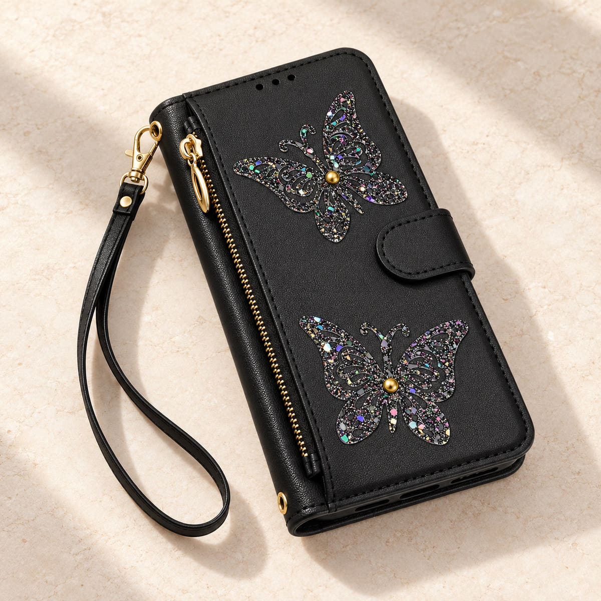 Black Butterfly iPhone wallet case — closed cover and zip pocket on a tabletop
