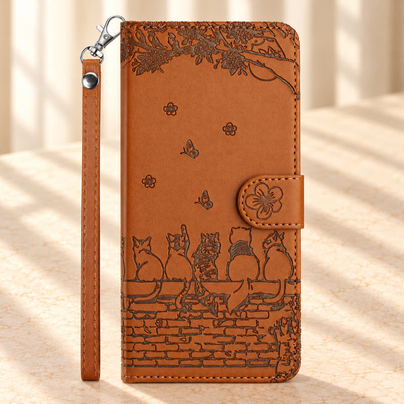 Cat Garden wallet phone case in Cognac Brown with embossed cats on a brick wall, a flower tab and matching wrist strap.