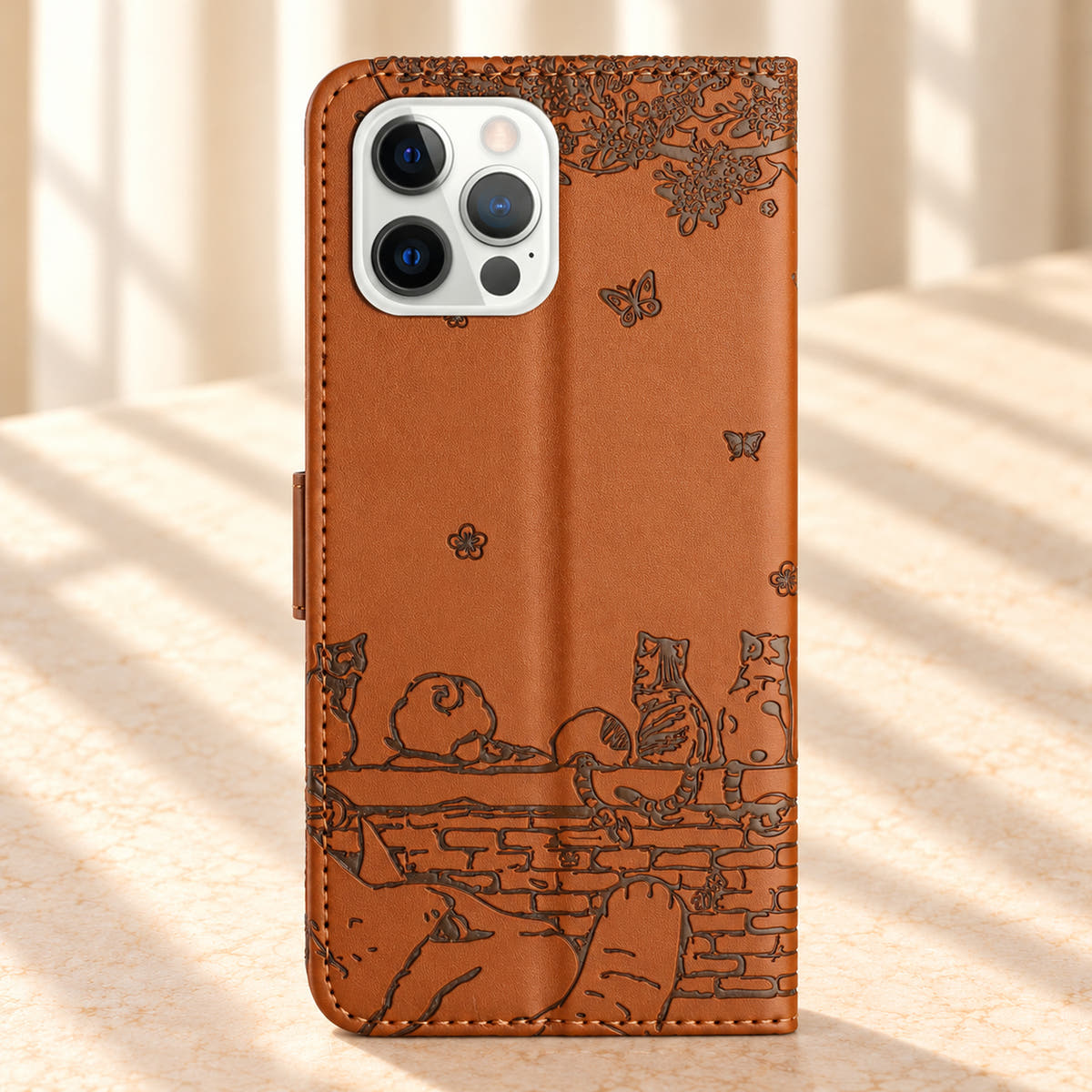 Rear of the Cognac Brown Cat Garden wallet case, showing the embossed cat scene and camera opening.