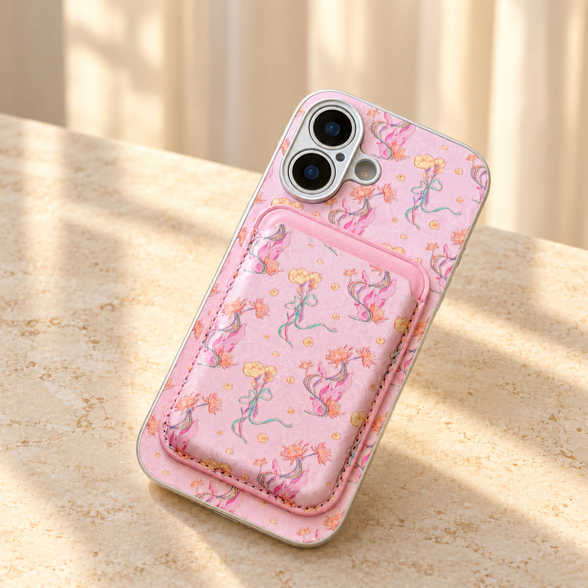 Pink Elysia Floral phone case and attached card wallet resting on a warm cream stone tabletop.