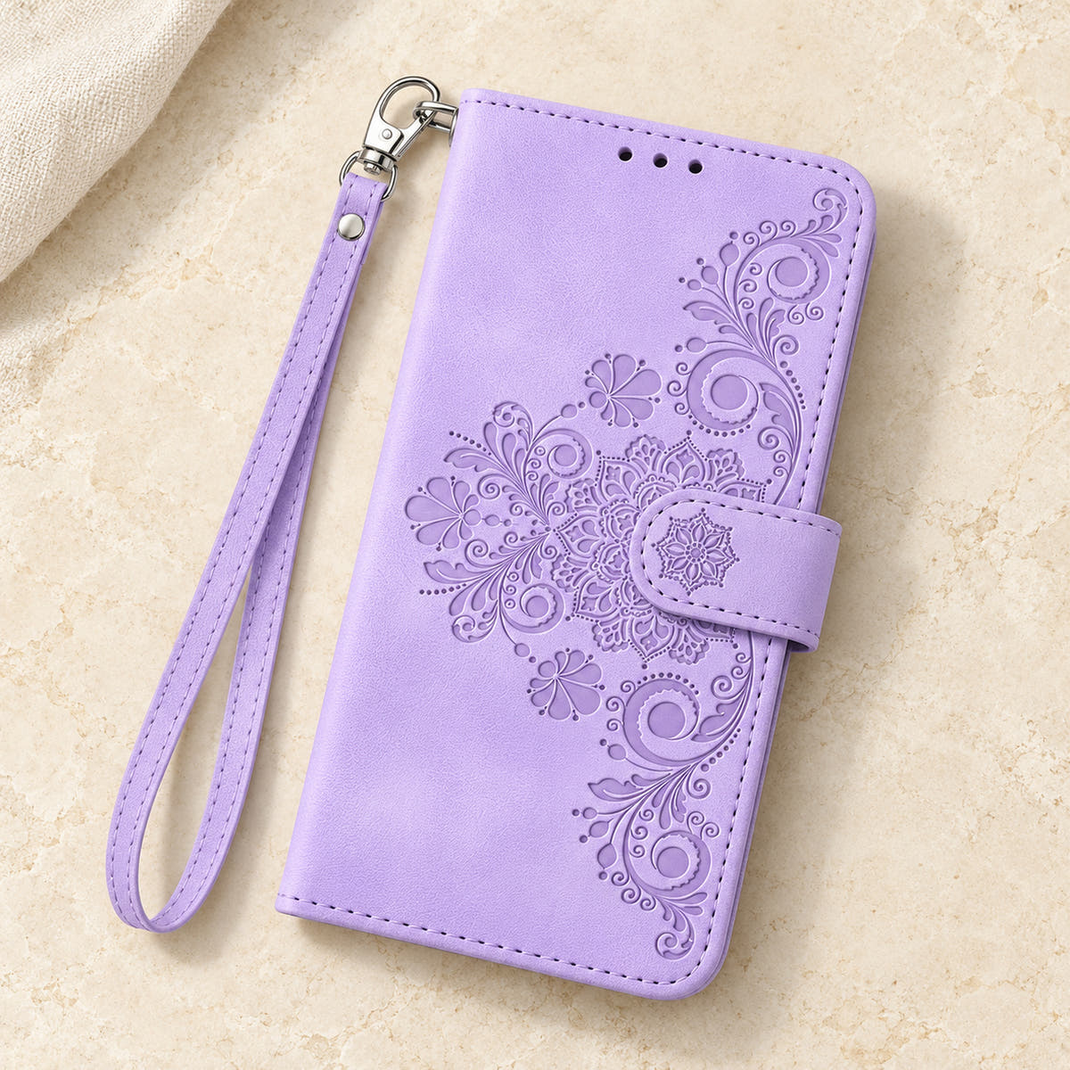 Floral embossed iPhone flip wallet case in Lavender — overhead view of floral front and matching wrist strap
