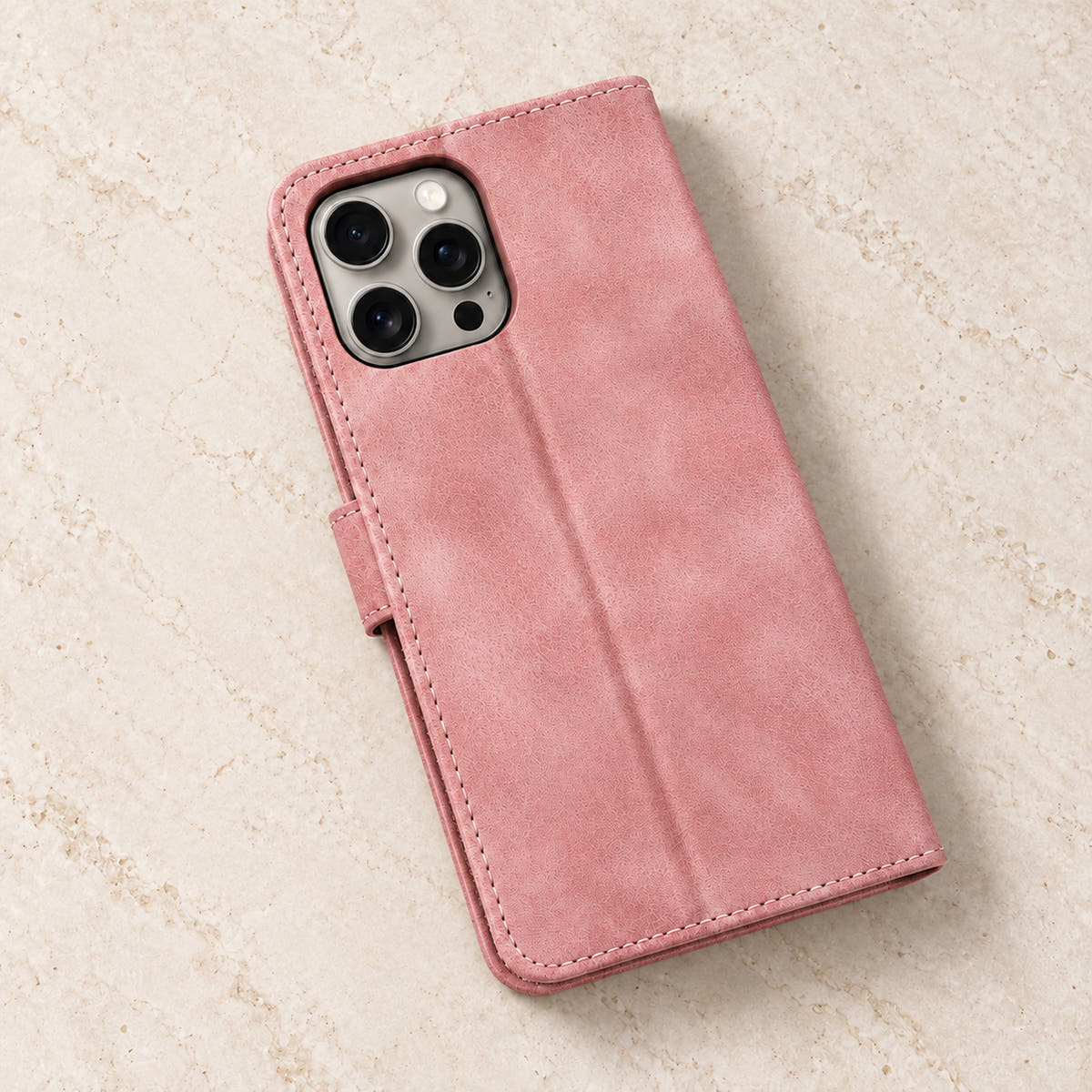 Floral embossed iPhone flip wallet case in Pink — plain rear panel and three-lens camera opening