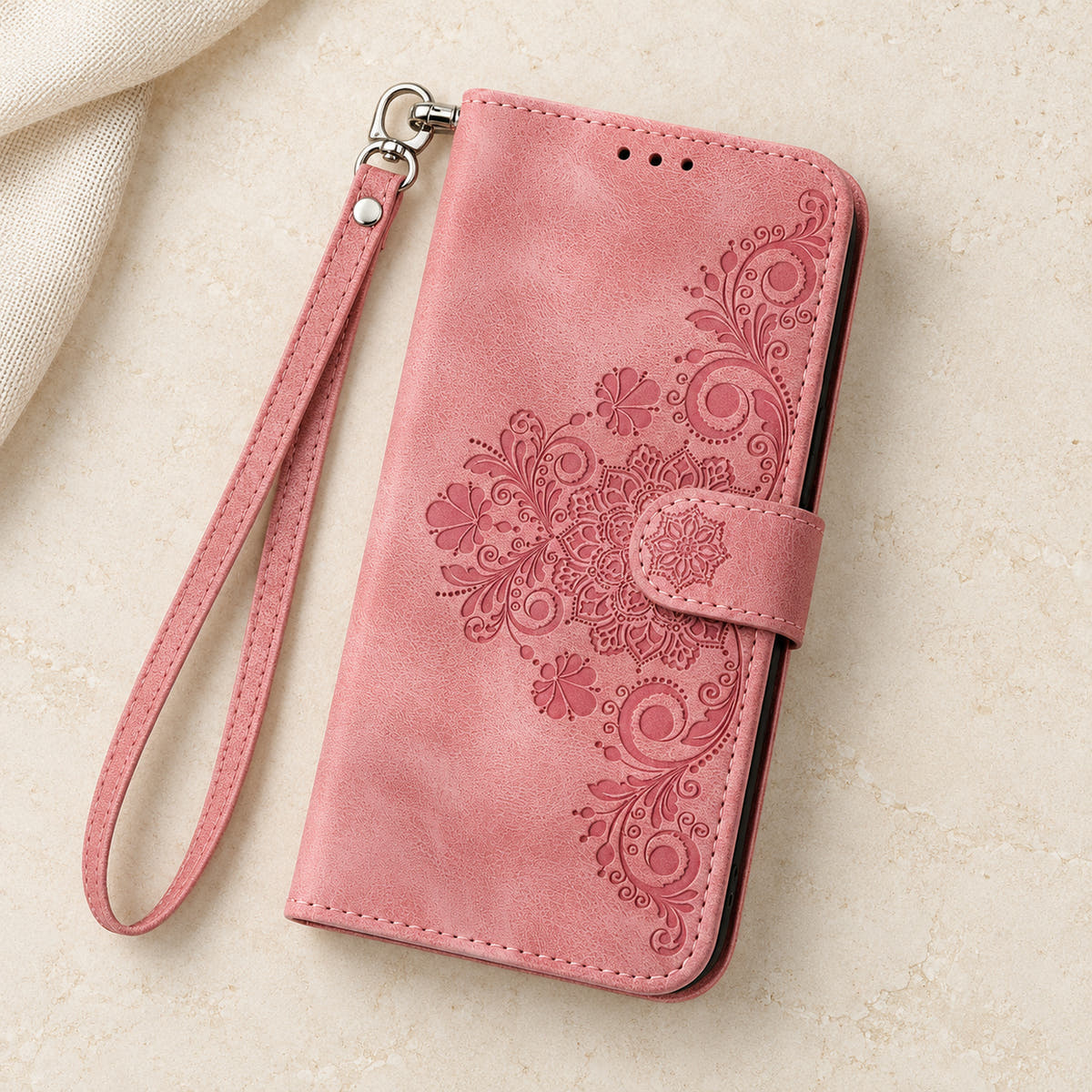 Floral embossed iPhone flip wallet case in Pink — overhead view of floral front and matching wrist strap