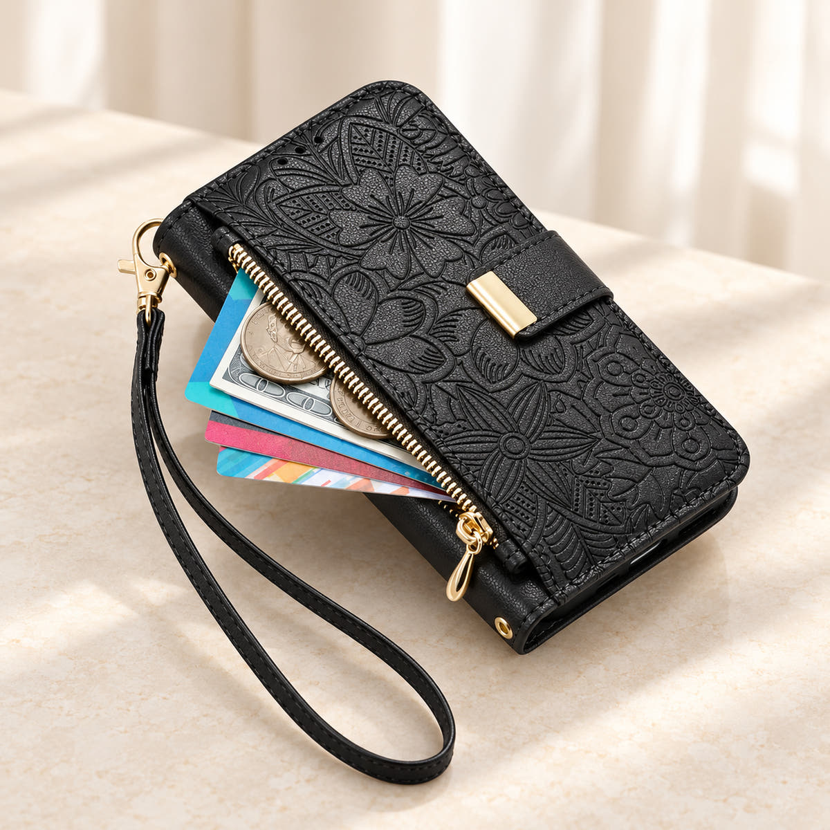 Black floral iPhone wallet case with the front zip pouch open, showing space for small essentials and the matching wrist strap