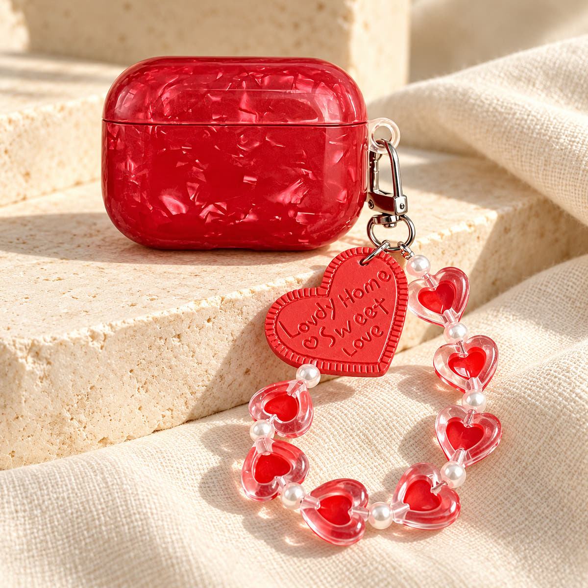 Garnet Marble AirPods case — wide finish detail with glossy red finish and heart-bead charm strap