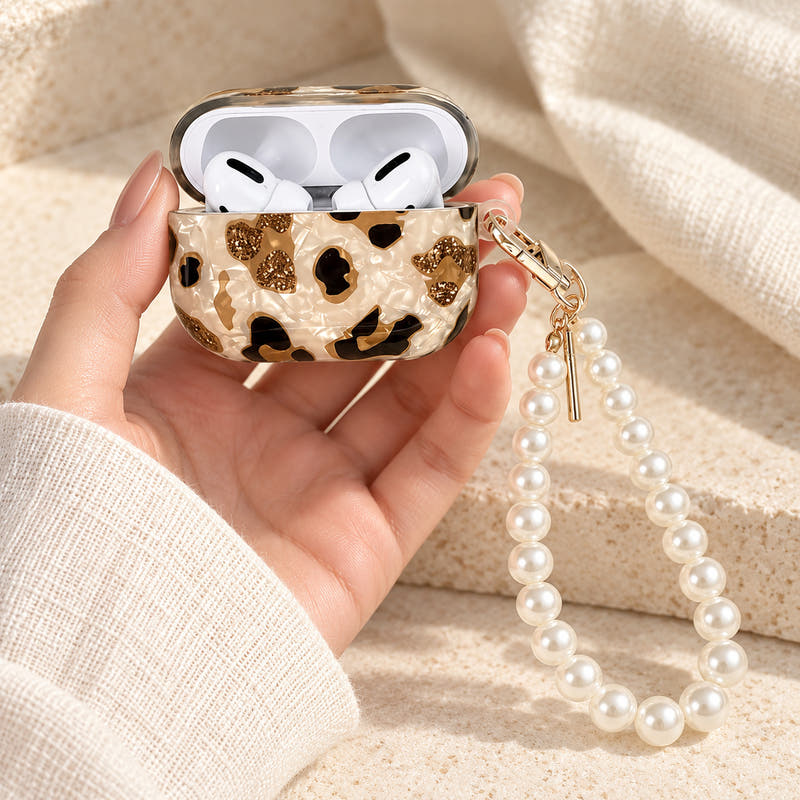 Gilded Leopard Heart AirPods case Design #1 — handheld showing its pearl-style wrist loop