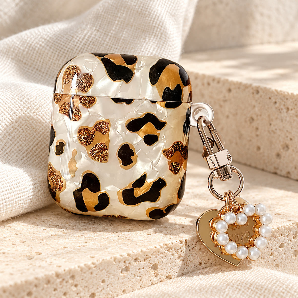 Gilded Leopard Heart AirPods case Design #2 — charm detail showing its pearl-style heart charm