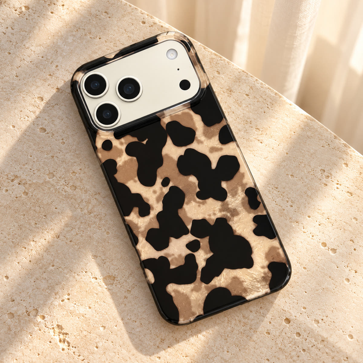 Glam Kitty case without kitty resting diagonally on cream limestone with its glossy rear visible.