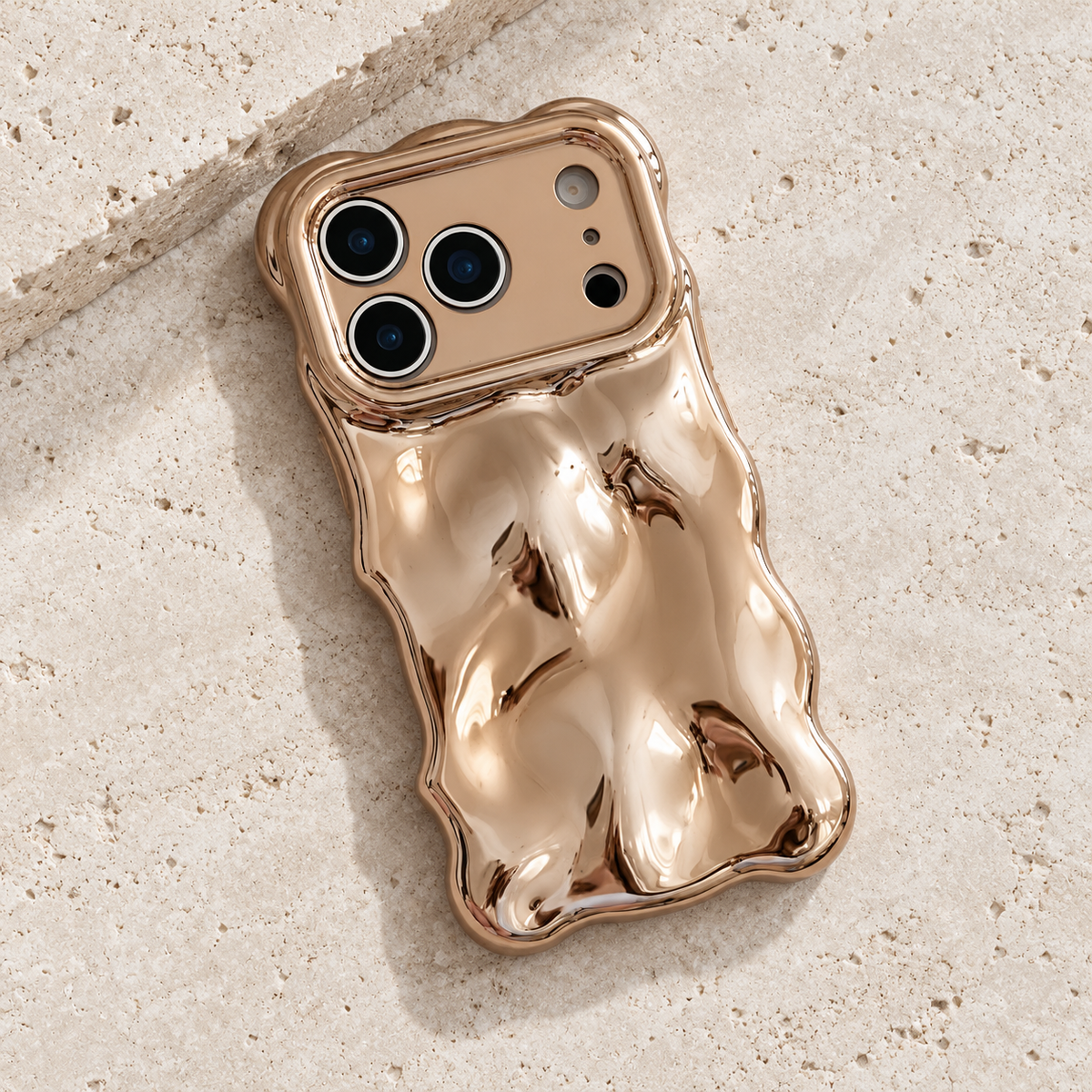 Diagonal flat-lay of the Champagne Liquid Chrome Wave case showing its wavy outline.