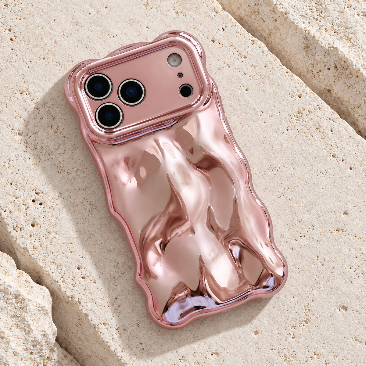 Diagonal flat-lay of the Rose Pink Liquid Chrome Wave case showing its wavy outline.