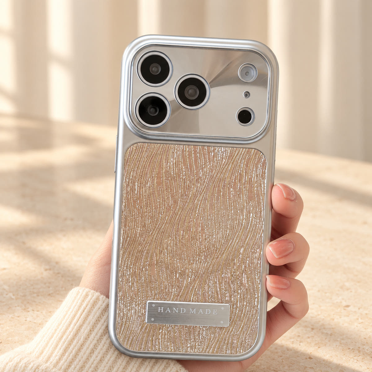 Luna Belle textured shimmer iPhone case in Beige, held upright.