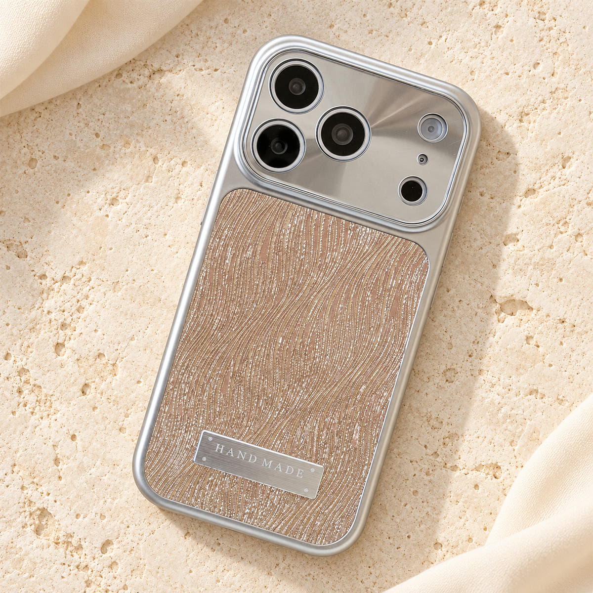 Luna Belle textured shimmer iPhone case in Beige, resting on cream stone.