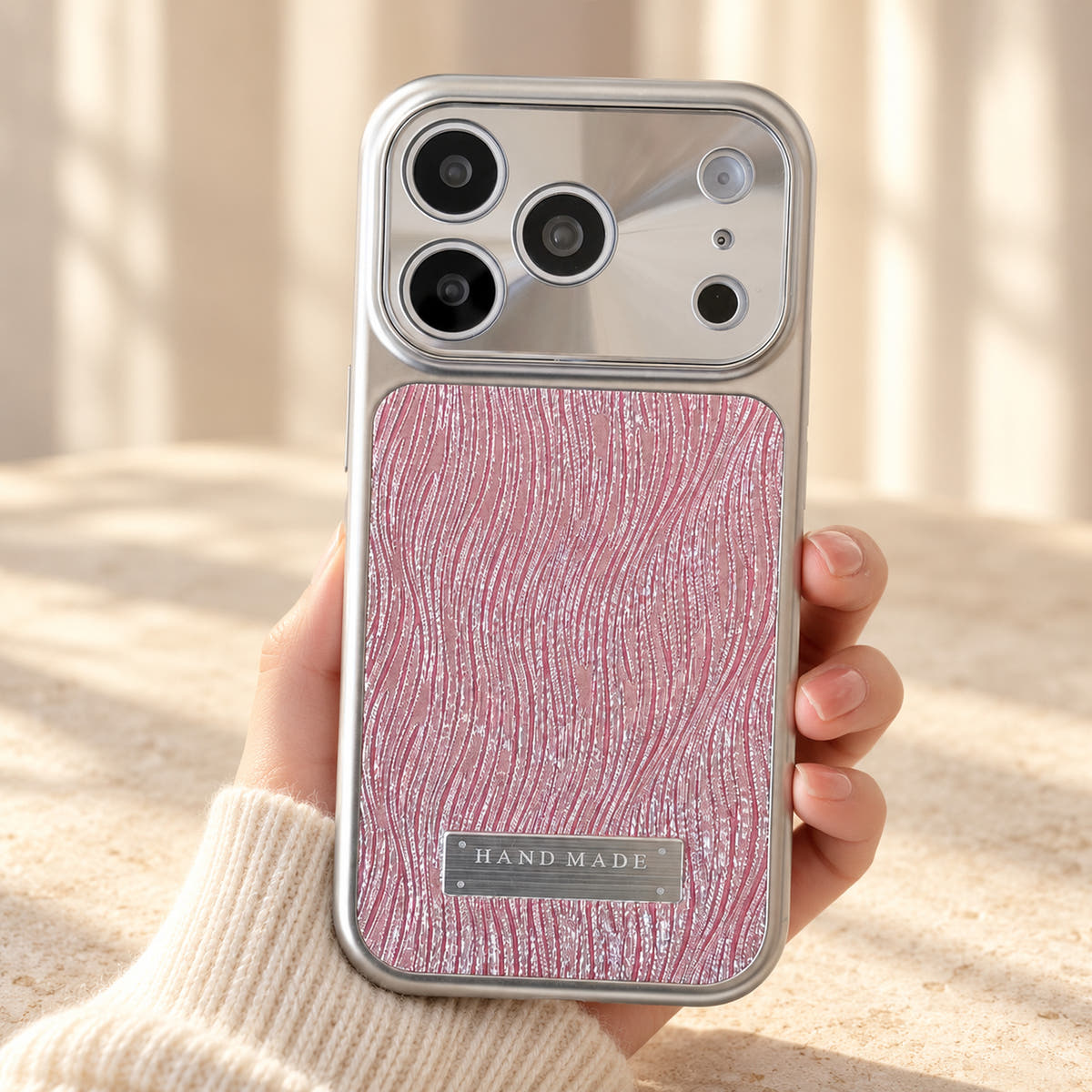Luna Belle textured shimmer iPhone case in Pink, held upright.