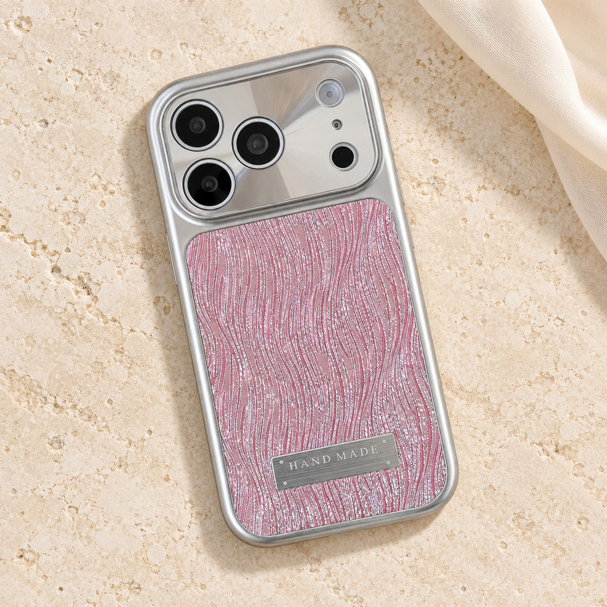 Luna Belle textured shimmer iPhone case in Pink, resting on cream stone.