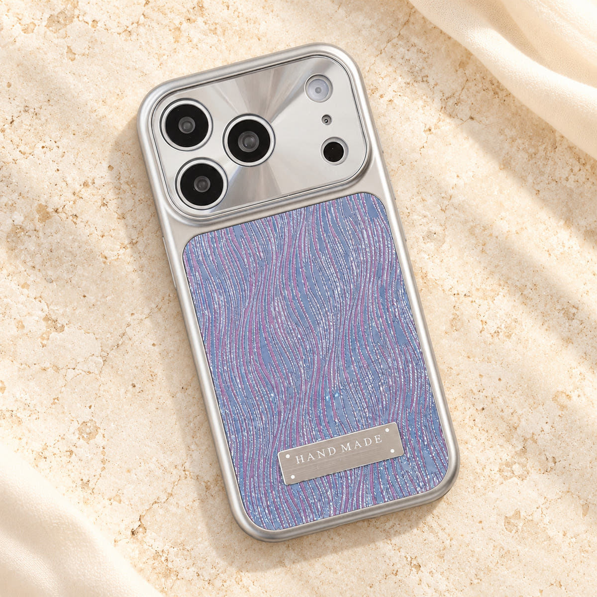 Luna Belle textured shimmer iPhone case in Purple, resting on cream stone.