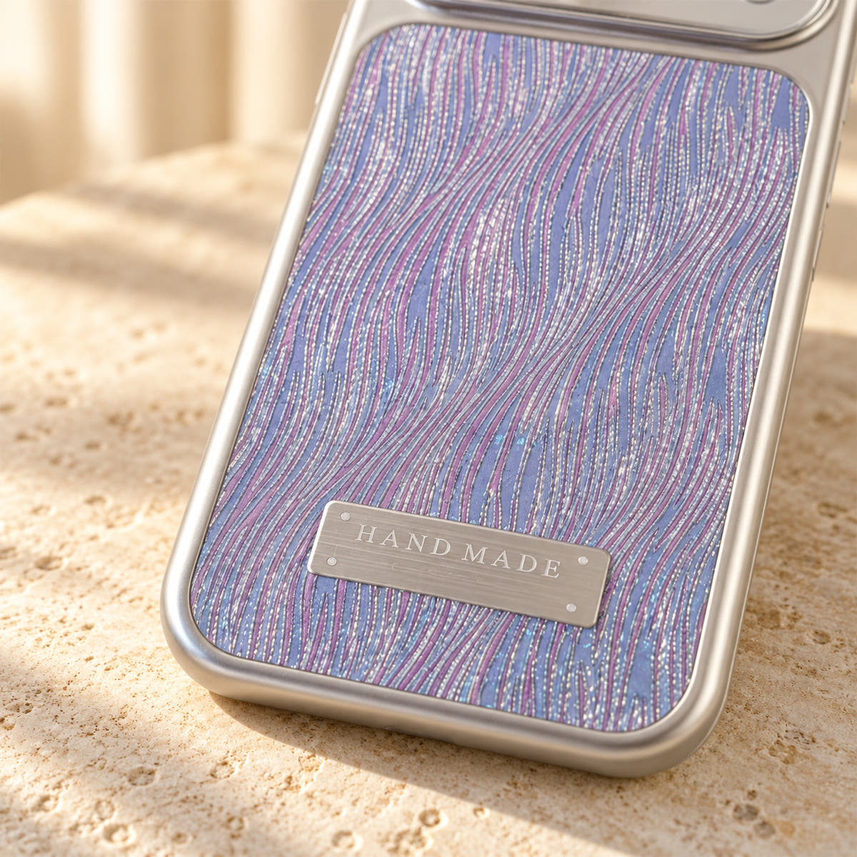 Luna Belle textured shimmer iPhone case in Purple, close-up of the wave texture and silver-tone plaque.