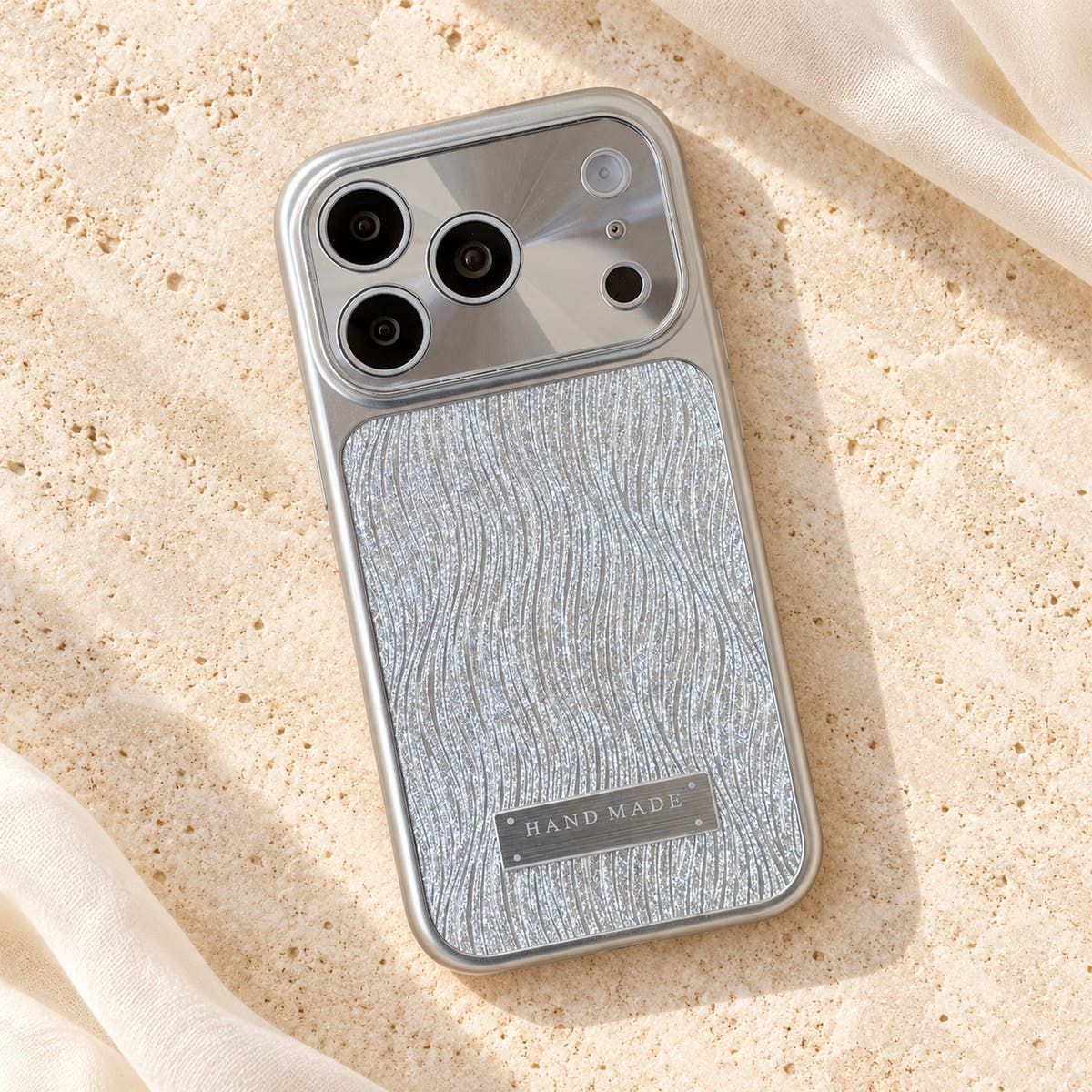 Luna Belle textured shimmer iPhone case in Silver, resting on cream stone.