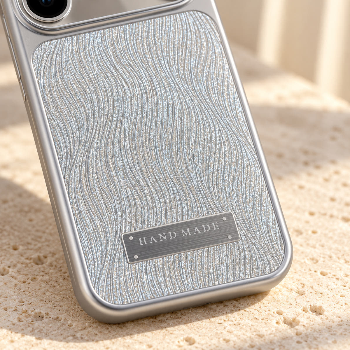 Luna Belle textured shimmer iPhone case in Silver, close-up of the wave texture and silver-tone plaque.