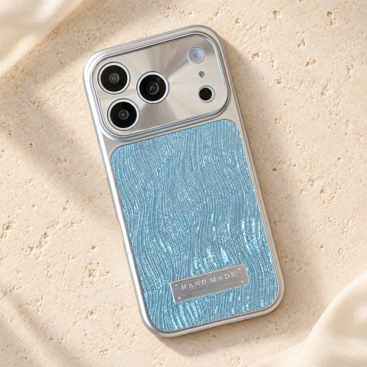 Luna Belle textured shimmer iPhone case in Sky Blue, resting on cream stone.