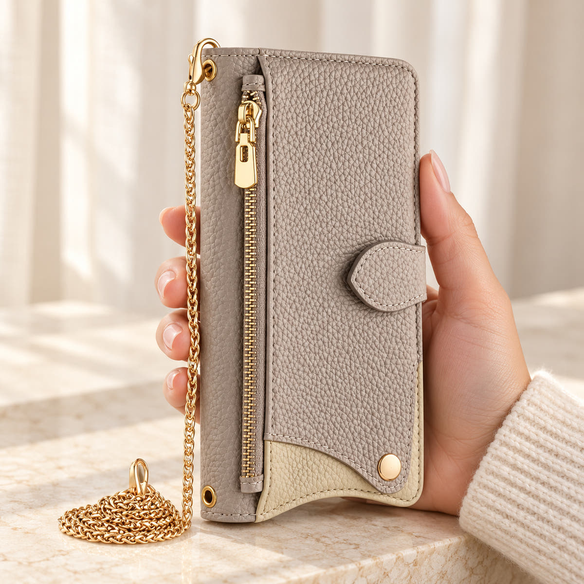 Luxe Colourblock iPhone wallet case in Beige held upright, showing the zip pocket, cream contrast panel and chain
