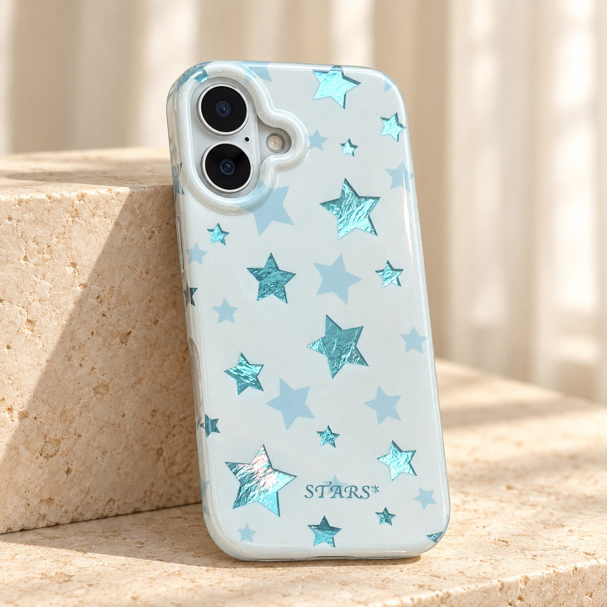 Metallic Dots & Stars iPhone case in Blue — tabletop view