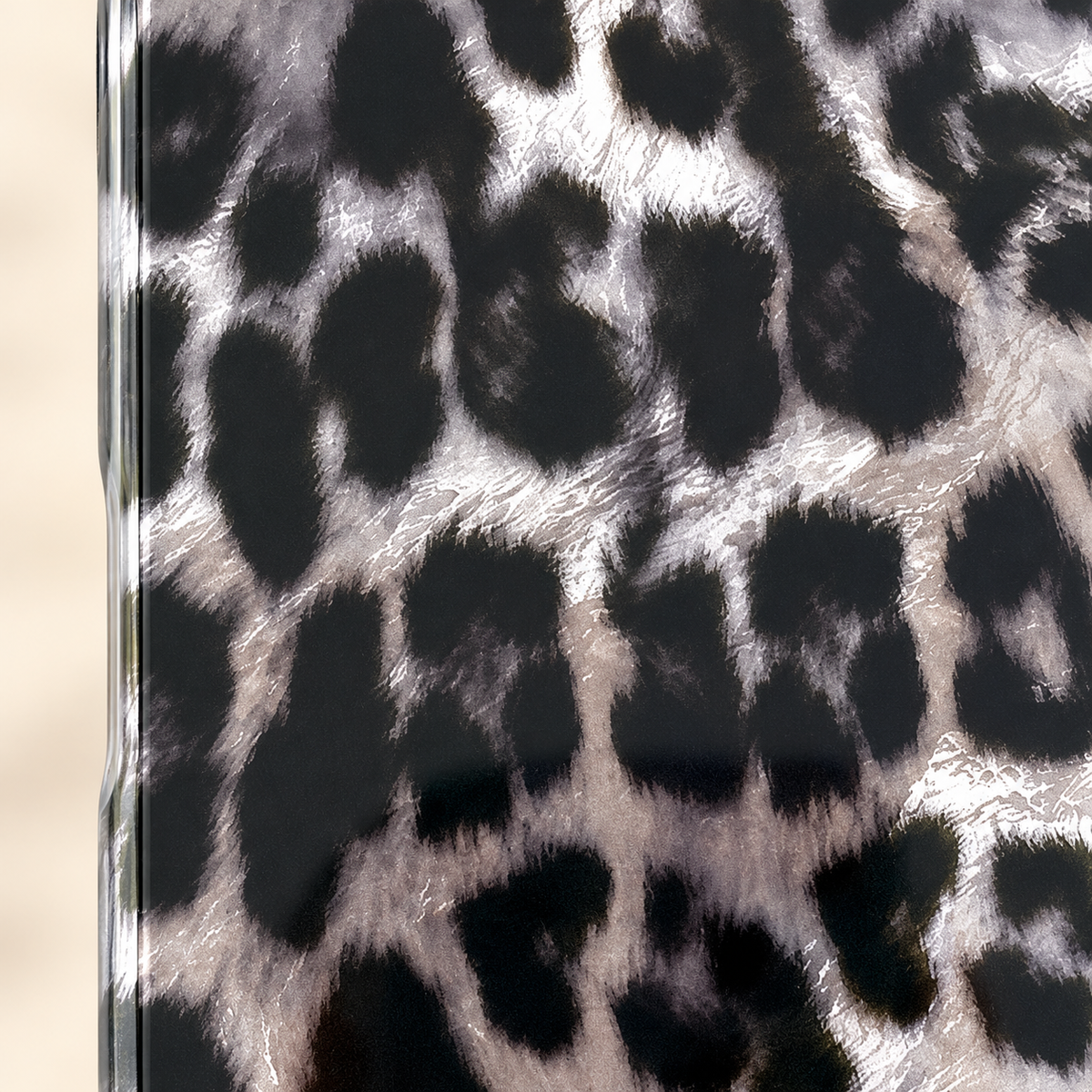 Close-up of the smooth glossy leopard print beside the case’s clear edge.