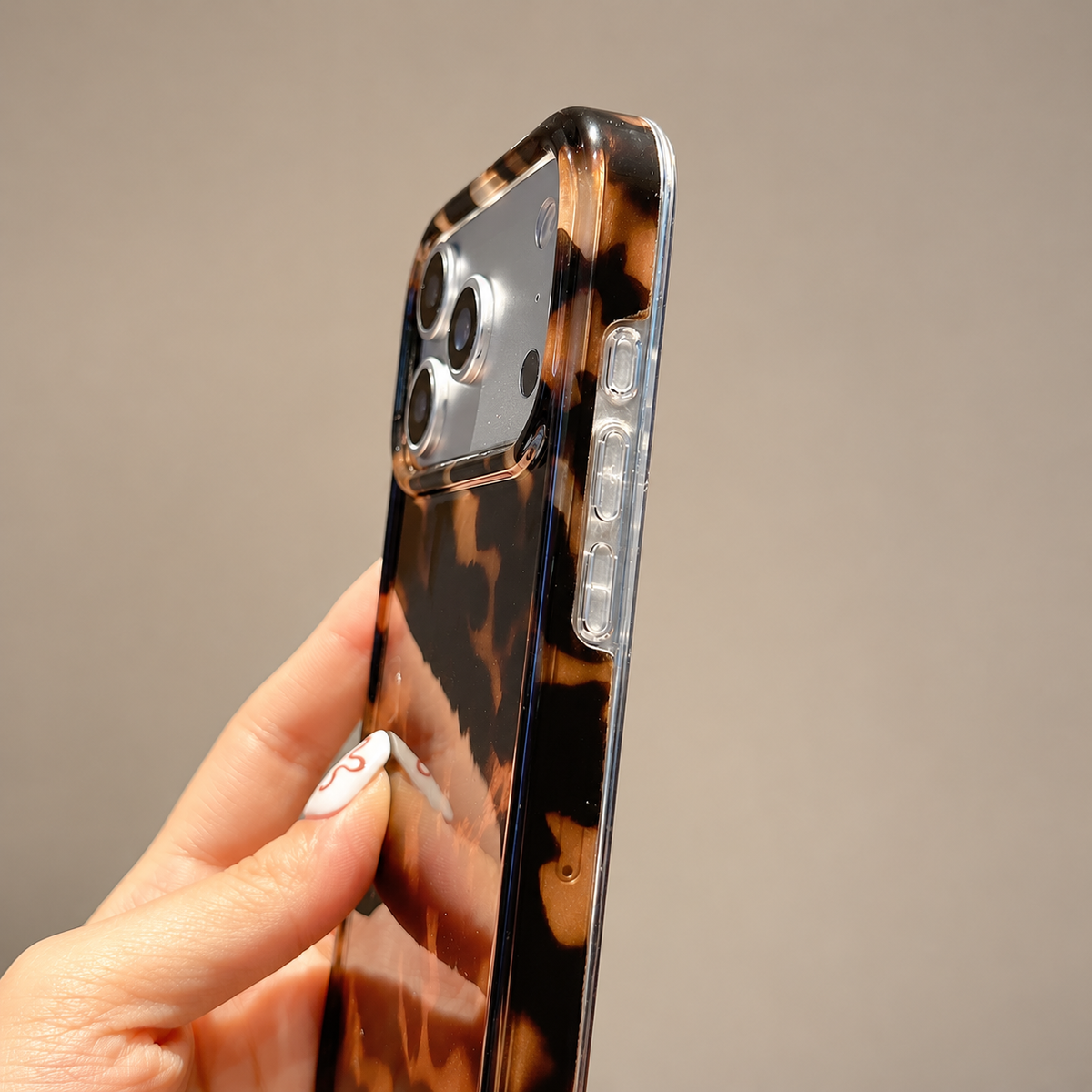 Dark Tortoiseshell iPhone case with black and warm brown mottled pattern — clear side and button detail.