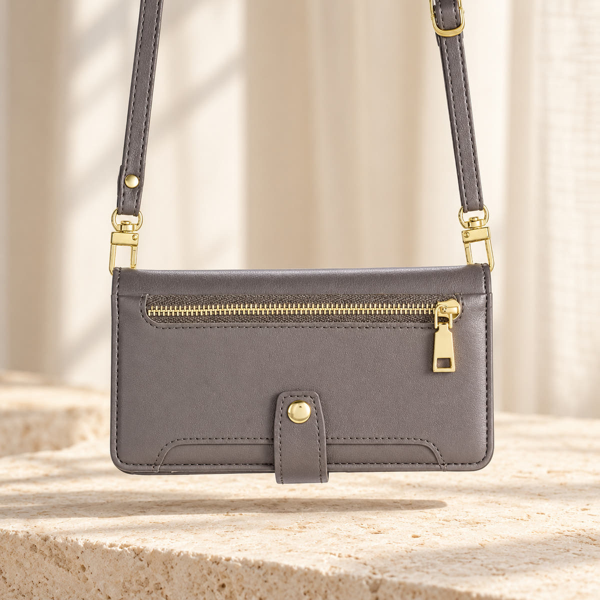 Minimal crossbody iPhone wallet case in Gray — landscape view with long matching shoulder strap and gold-tone clips