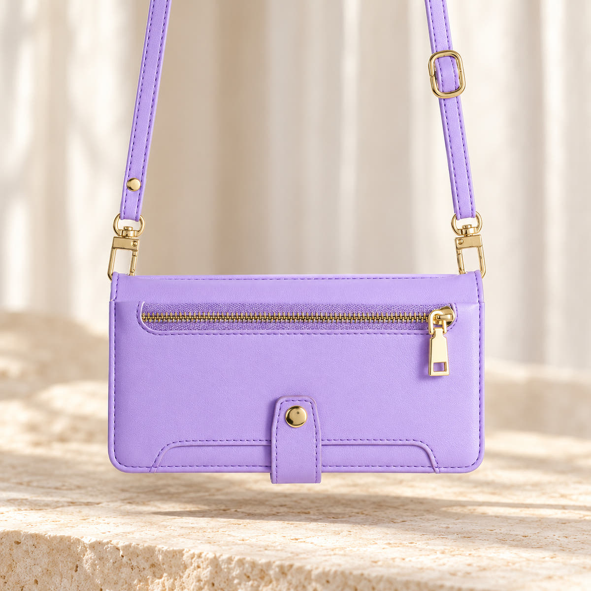 Minimal crossbody iPhone wallet case in Lavender — landscape view with long matching shoulder strap and gold-tone clips