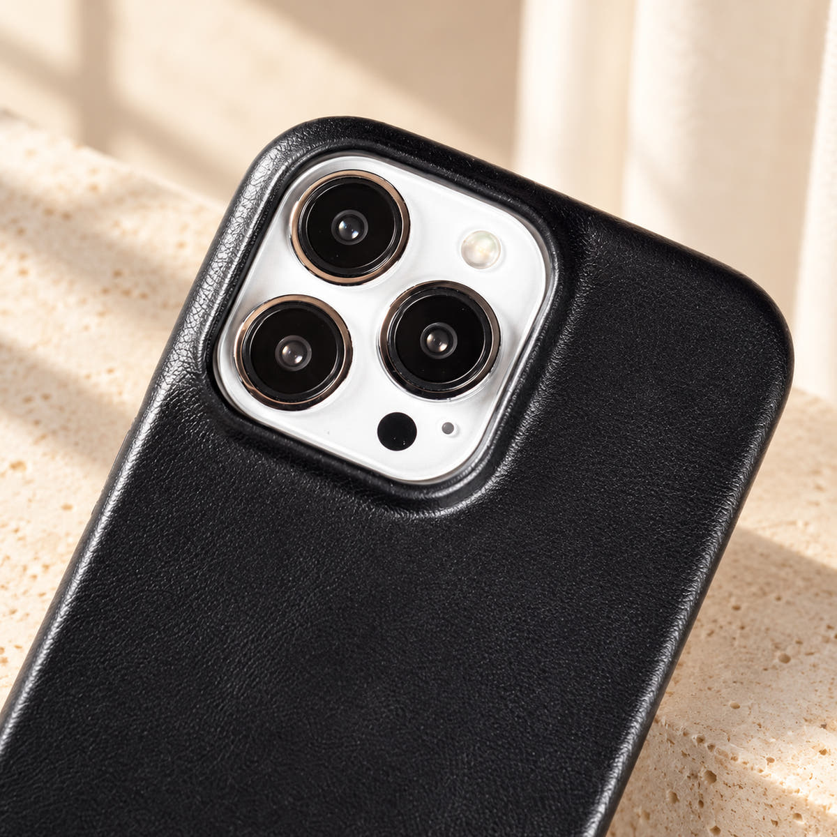 Minimal leather-look iPhone case in Black, close-up of the matching camera border.