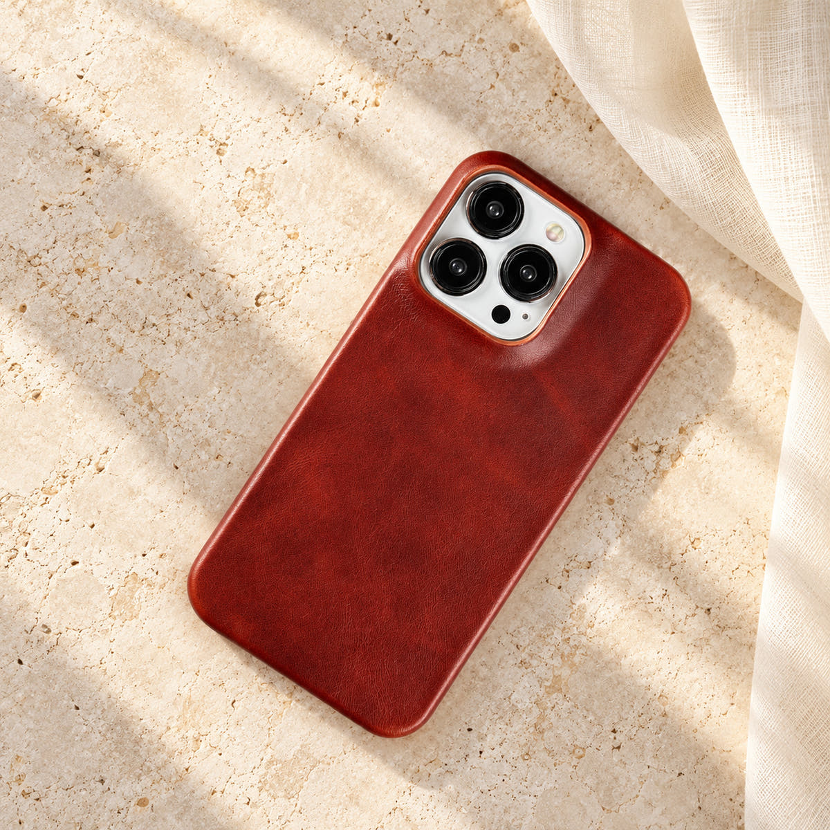 Minimal leather-look iPhone case in Brown, full rear view on an ivory tabletop.