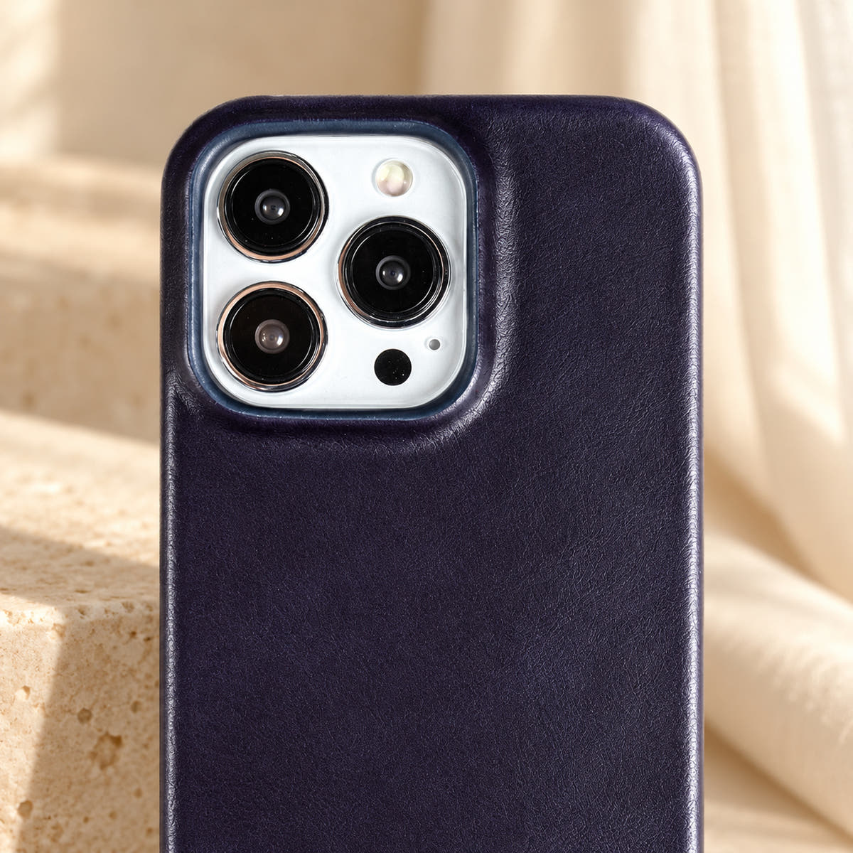 Minimal leather-look iPhone case in Dark Blue, close-up of the matching camera border.