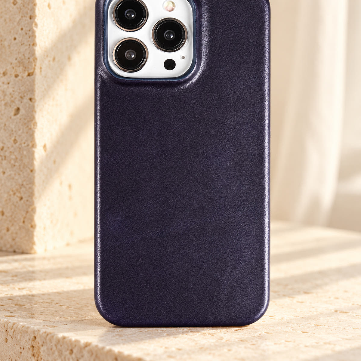 Minimal leather-look iPhone case in Dark Blue, close-up of the fine-grained back and rounded corners.