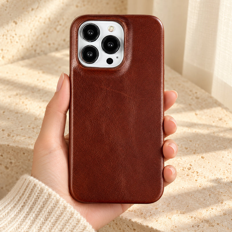 Minimal leather-look iPhone case in Dark Brown, held upright against a cream background.