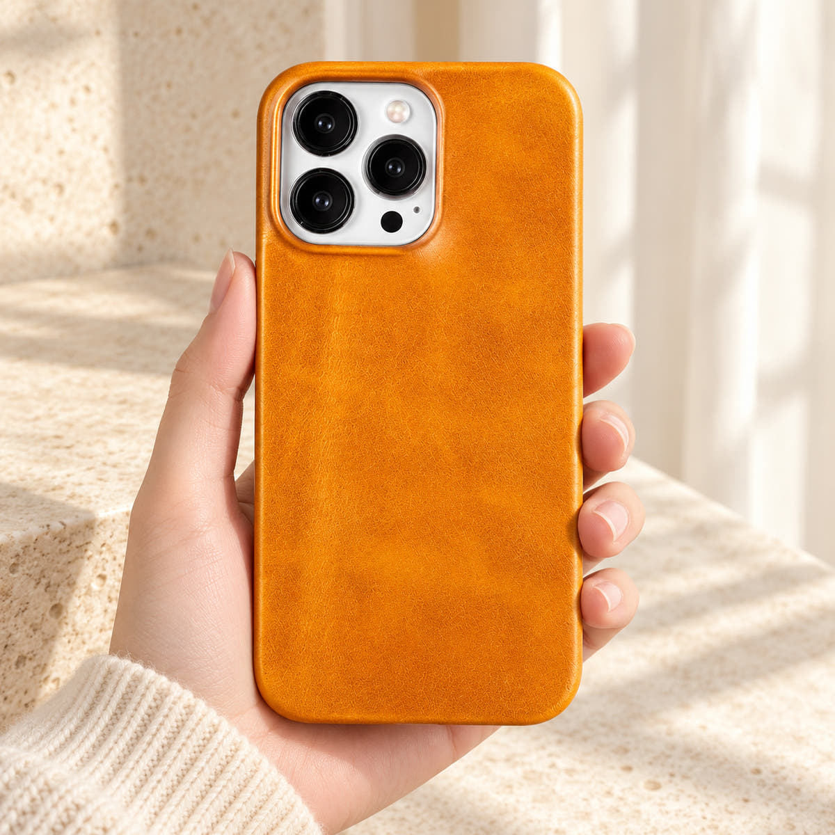 Minimal leather-look iPhone case in Yellow, held upright against a cream background.