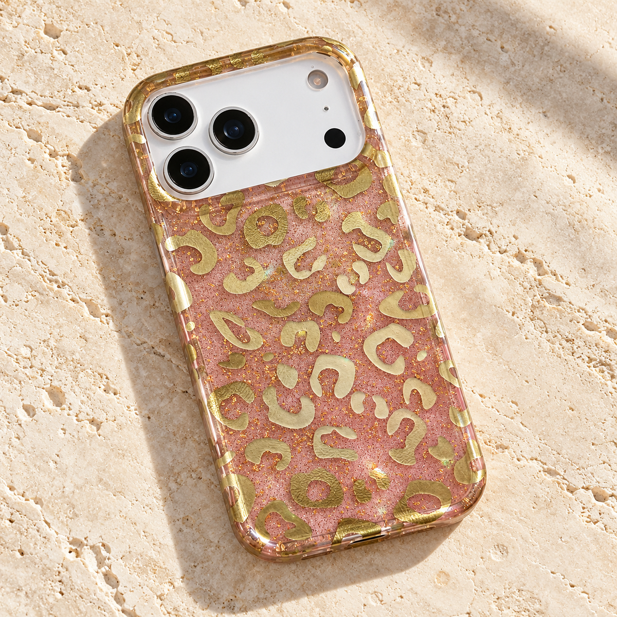 Pink & Gold Golden Blush Leopard case lying diagonally on cream limestone.
