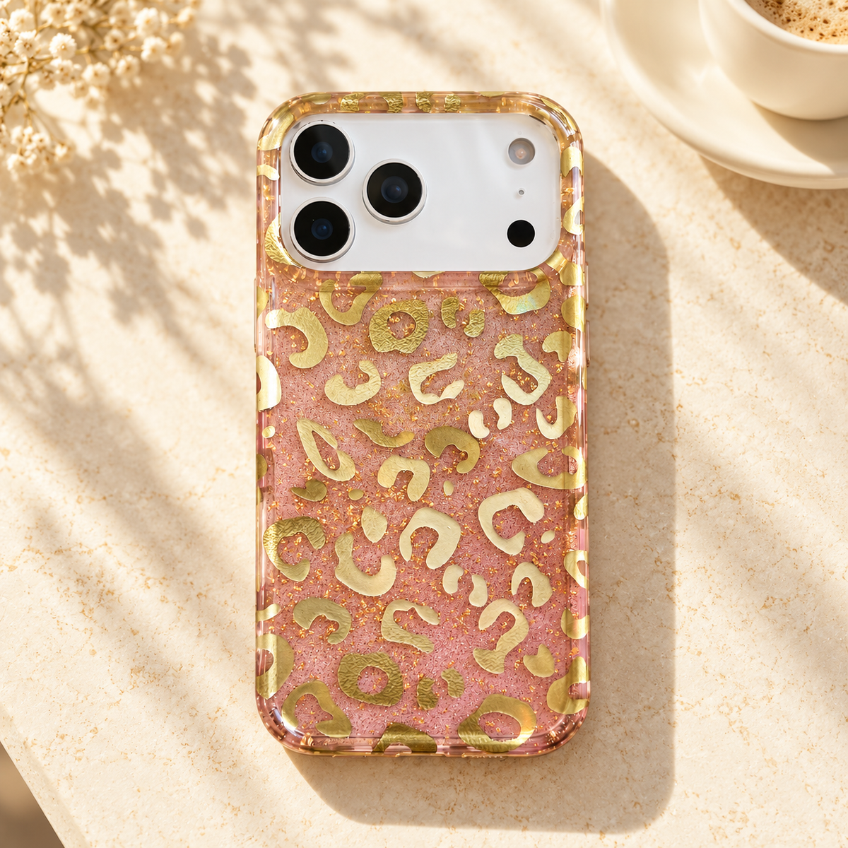 Pink & Gold case on a cream café table beside an ivory cup.