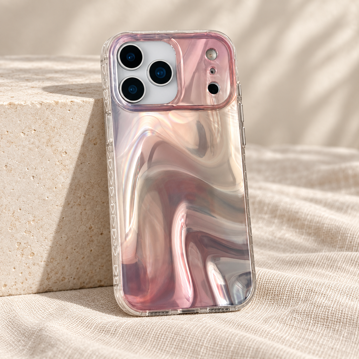 Iridescent Rose case leaning against a low ivory block on natural linen.