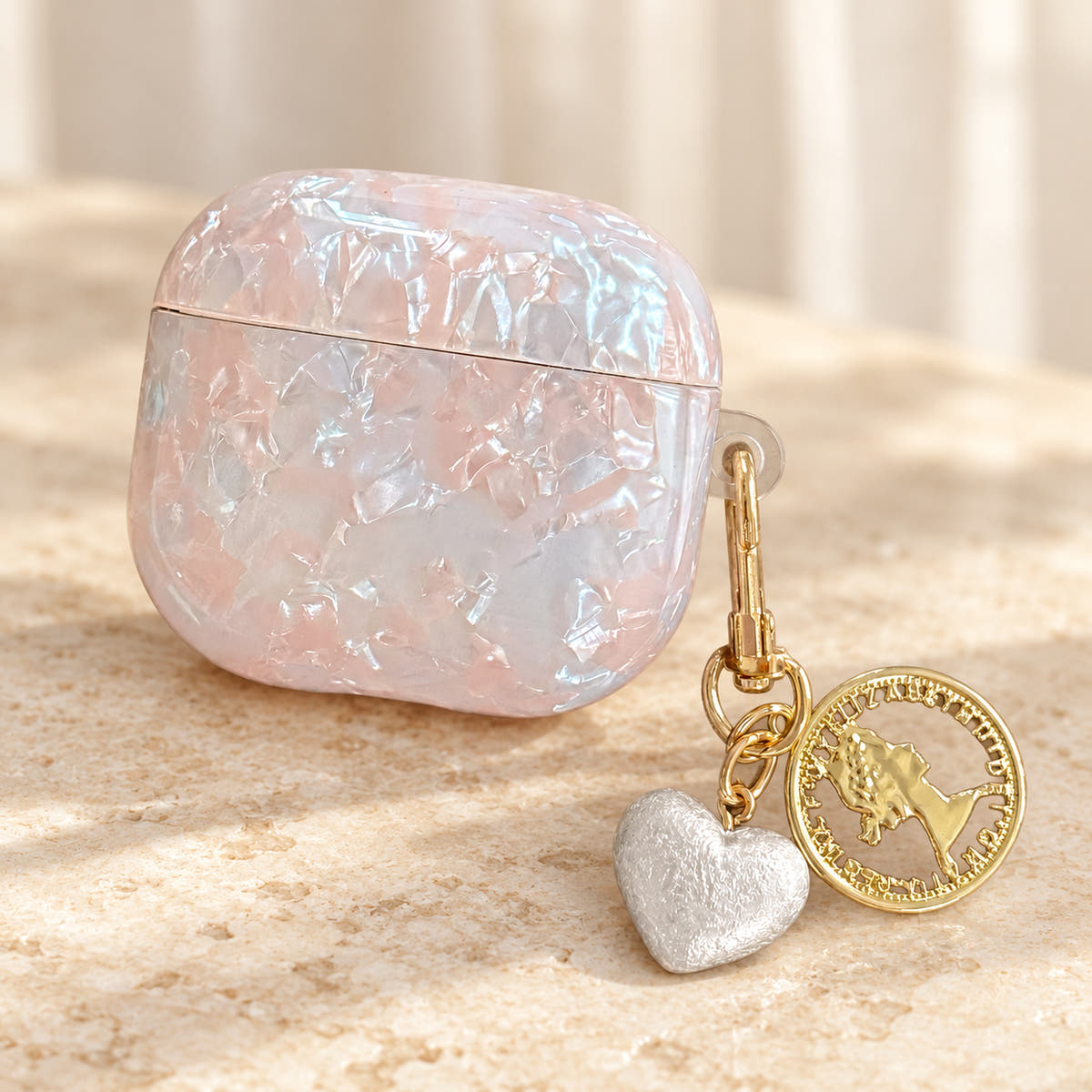 Opal Marble AirPods Case in Opal, charm close with original attached charms on a warm cream background