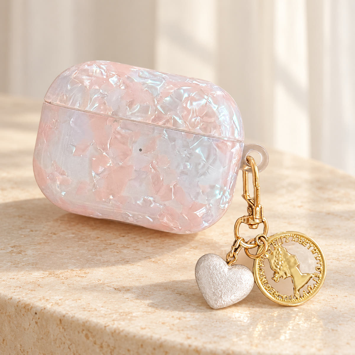Opal Marble AirPods Case in Opal, final view with original attached charms on a warm cream background