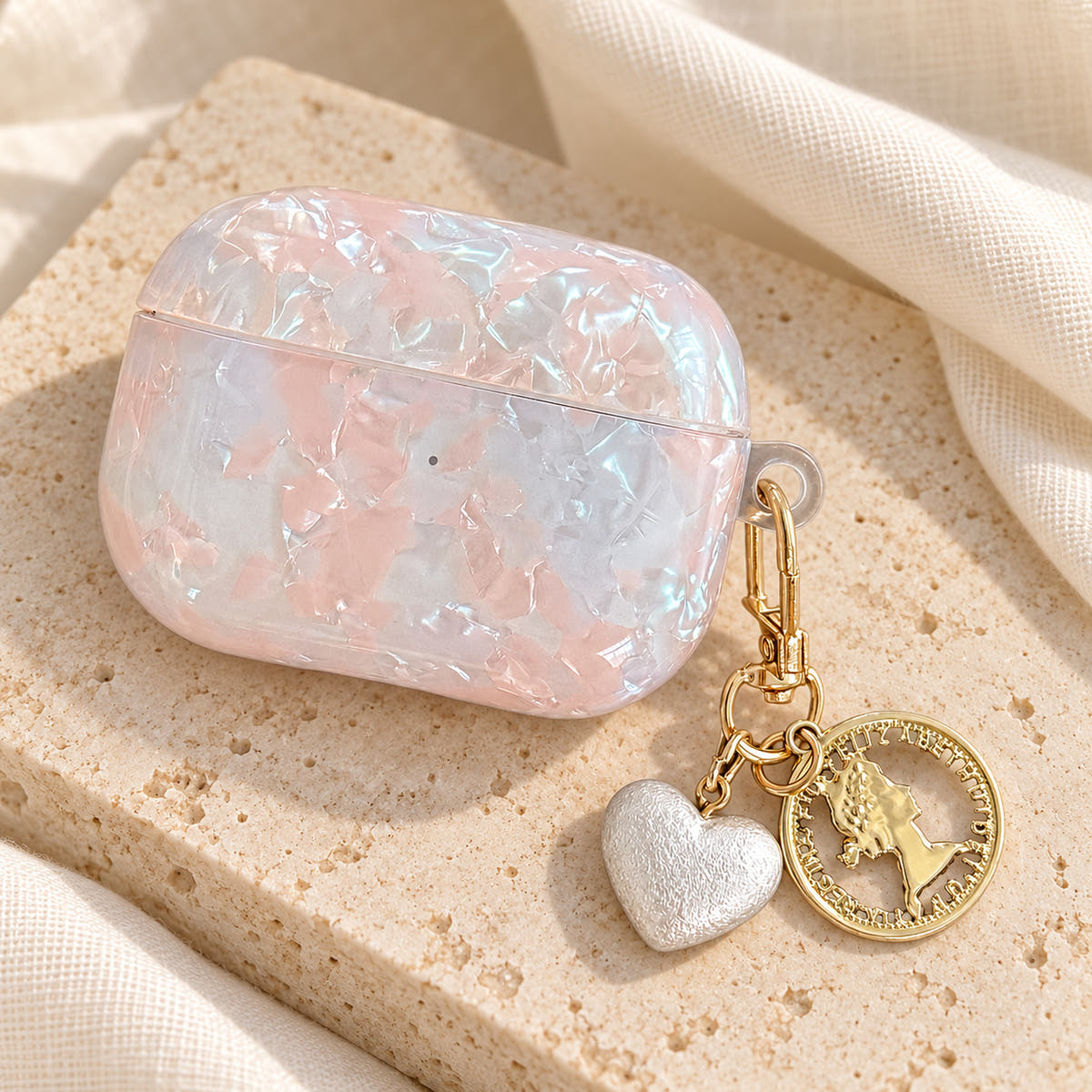 Opal Marble AirPods Case in Opal, linen flat with original attached charms on a warm cream background